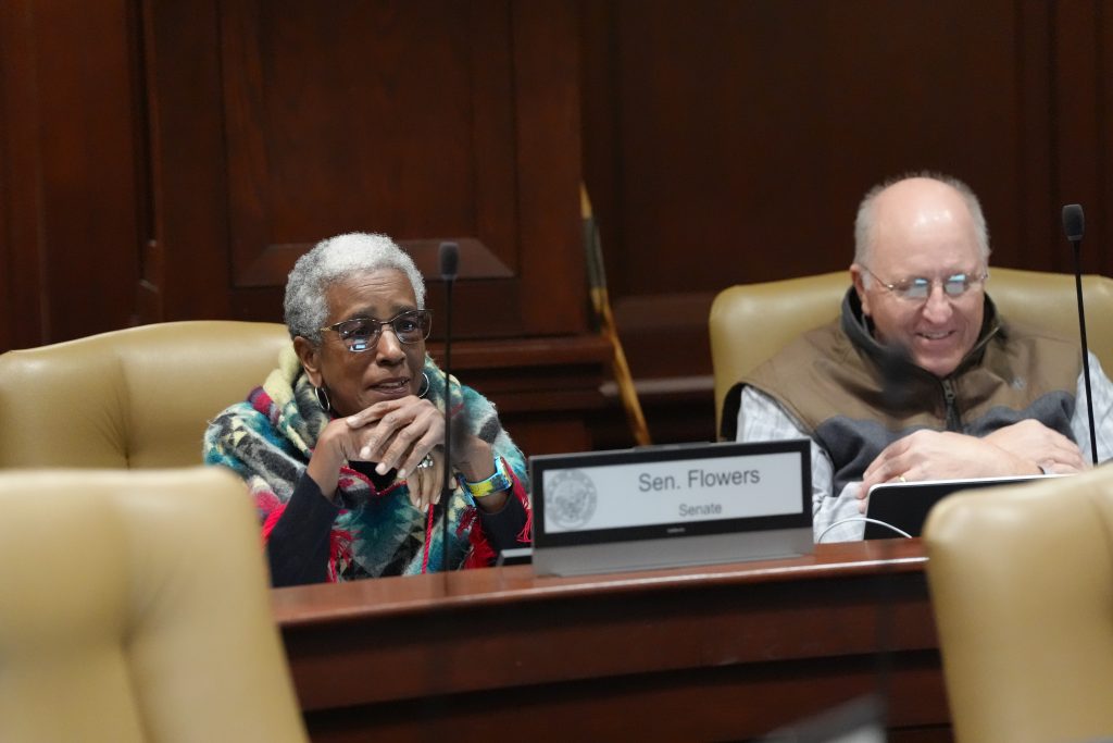 Senator Flowers and Senator Payton smile before a committee meeting begins.