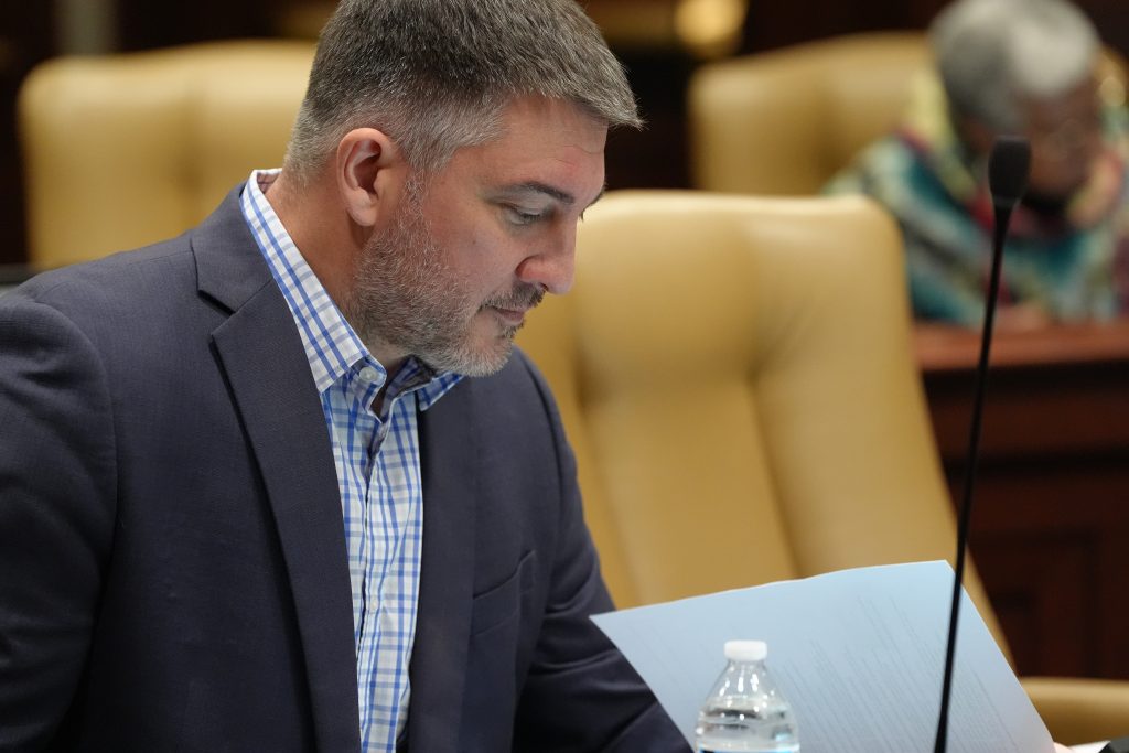 Senator Penzo reads documents during a committee meeting