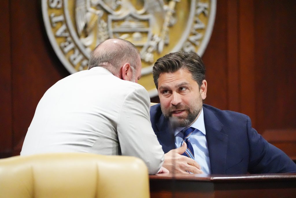 Senator Dismang talks with a colleague before a committee meeting