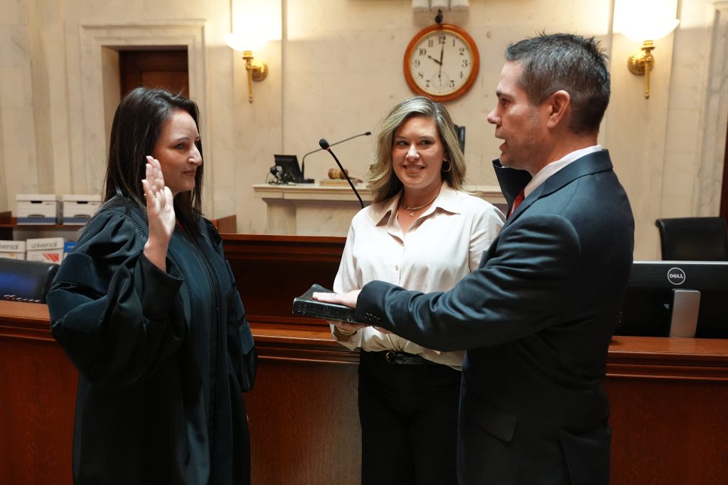 Senator Brad Simon is sworn in as Senator while his wife Stephanie looks on.