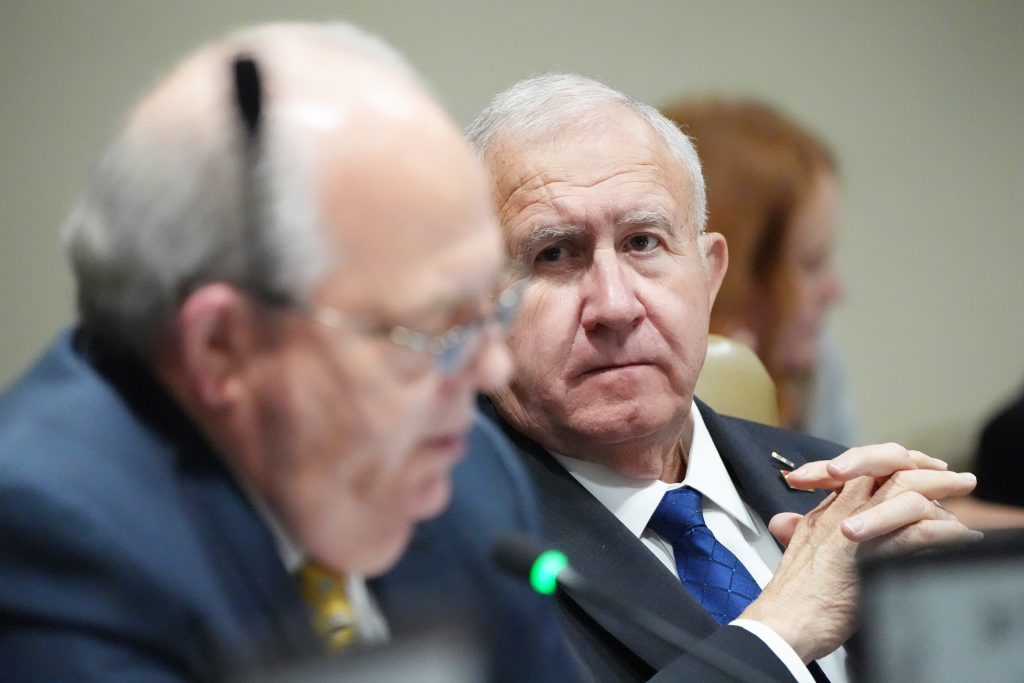 Senator Wallace listens intently as Senator Rice speaks. Senator Rice is out of focus in the foreground and Senator Wallace is the focus of the picture.