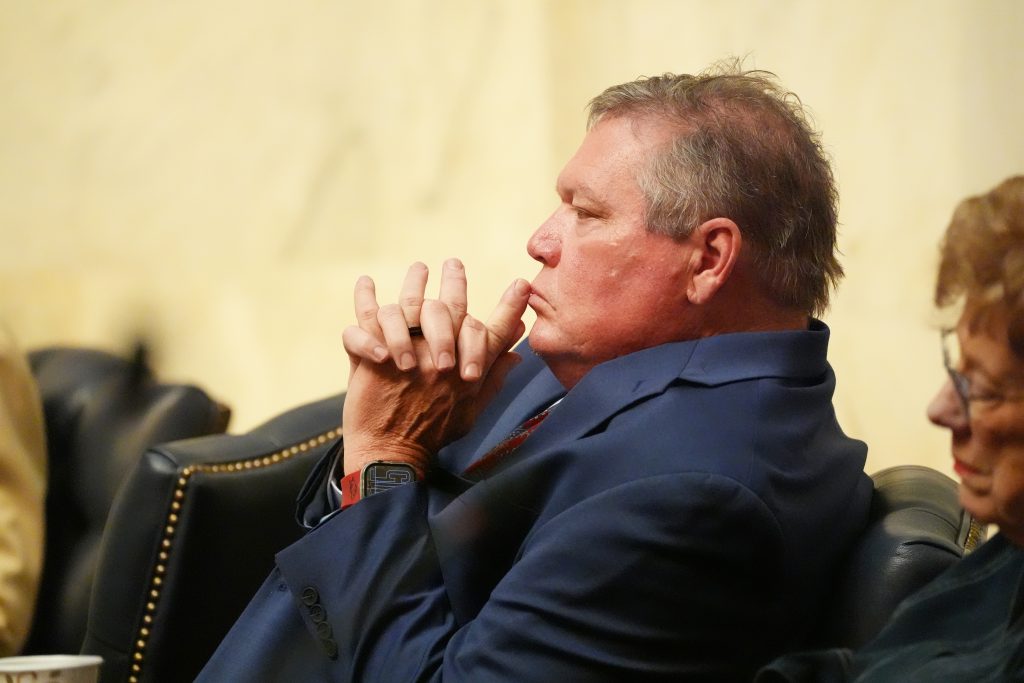 Senator King listens in the Senate Chamber during a business meeting. He is leaned back in his chair and his fingers are interlocked in front of him.