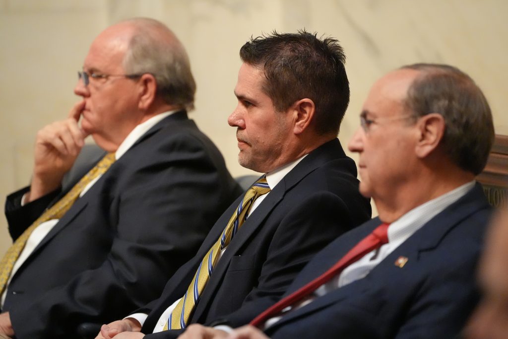 Senator Simon sitting between Senators Rice and Mark Johnson in the Senate chamber.