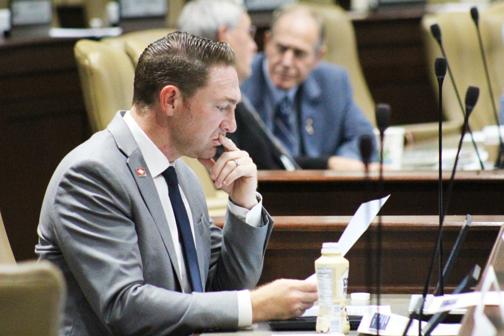 Senator Dees examines a report in a committee room