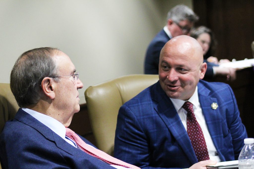 Senators McKee and Johnson talk in a committee room. The picture is focused on Senator McKee.