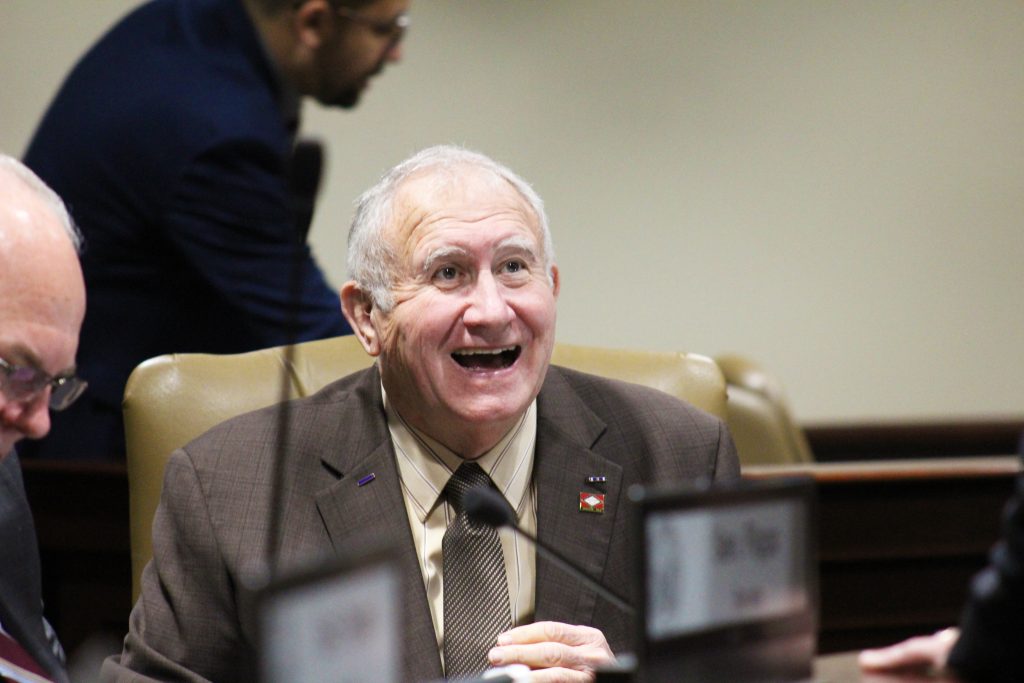 Senator Wallace smiling while seated in a committee room