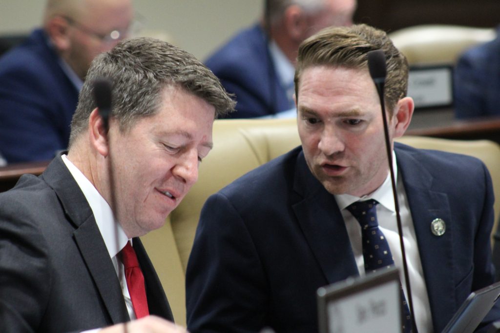 Senator Bryant talking with Senator Dees during a committee meeting