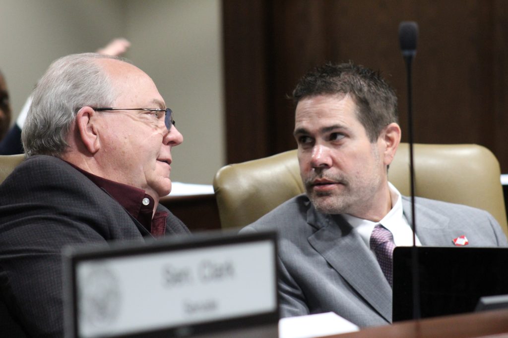 Brad Simon speaking with another senator during a committee meeting