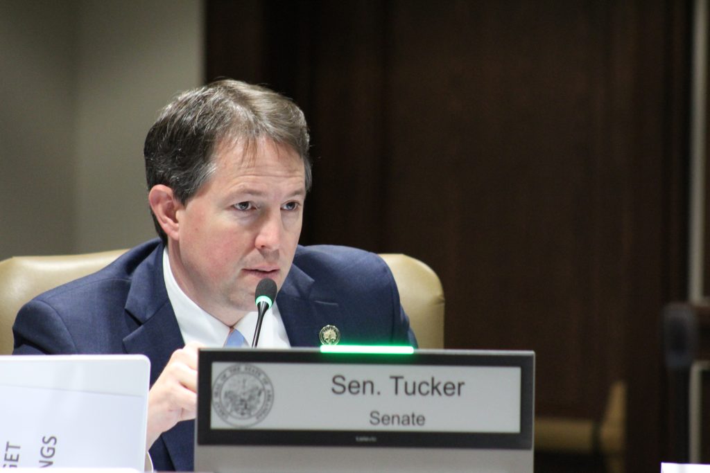Senator Tucker asks a question during a committee meeting