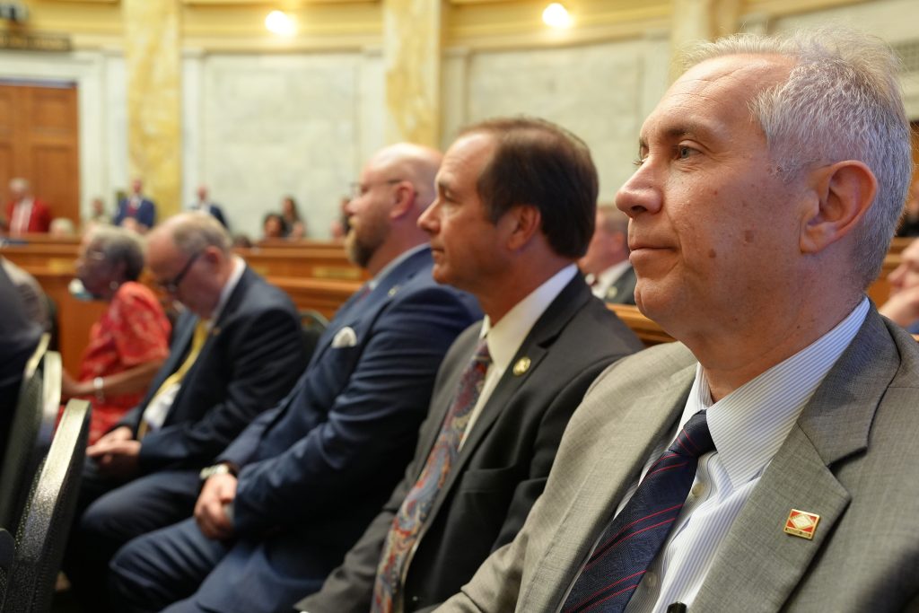 Senator Boyd listens in the House chamber to the governor's State of the State address. Senators Petty and Crowell are seen in the background.