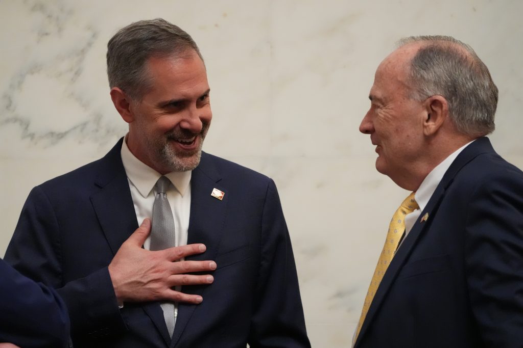 Senator Leding laughs while talking with Senator Caldwell in the Senate Chamber