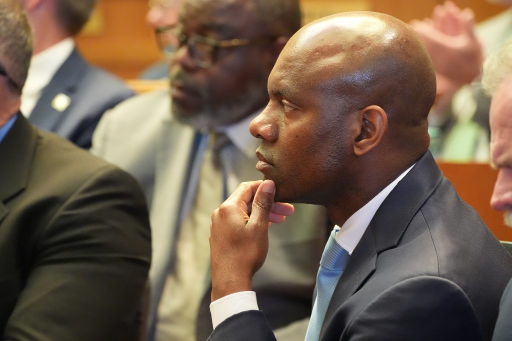 Senator Love holds his chin while listening to the State of the State address