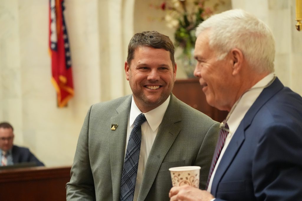 Senator Bart Hester smiles while talking with Senator Dan Sullivan