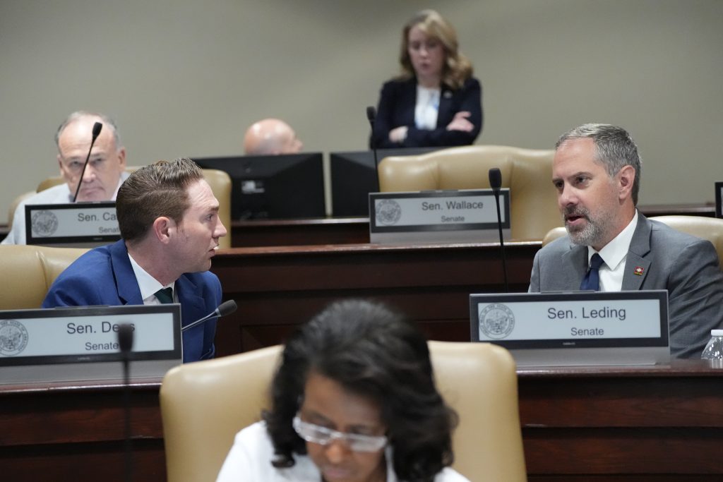 Senator Dees and Senator Leding talk before the start of a committee meeting.