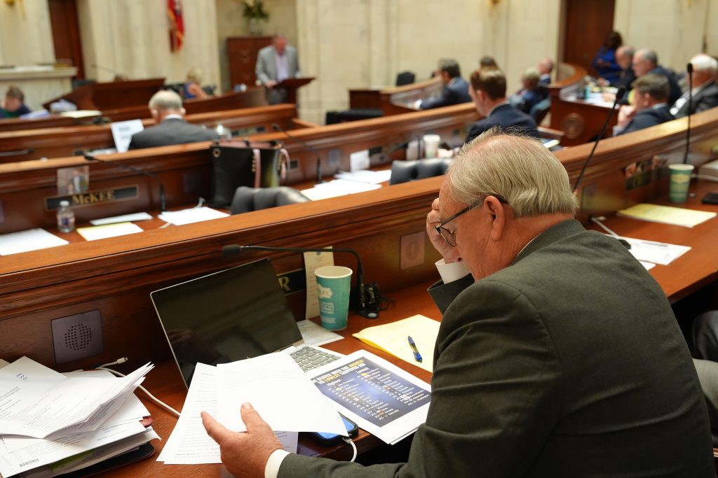 Senator Hammer reads some paperwork at his desk in the Senate chamber.