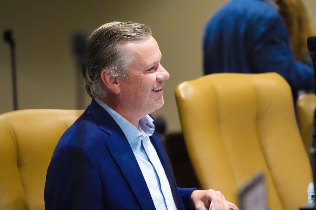 Senator Flippo smiles while listening to a colleague in a committee room
