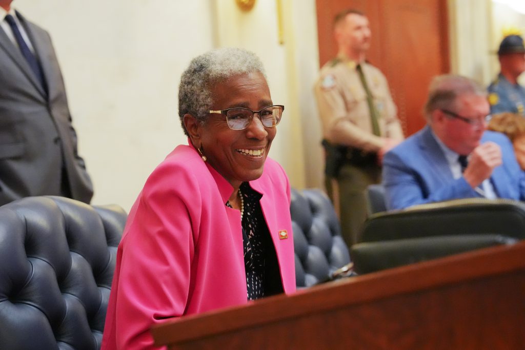 Senator Flowers smiles while sitting at her desk in the Senate chambers.