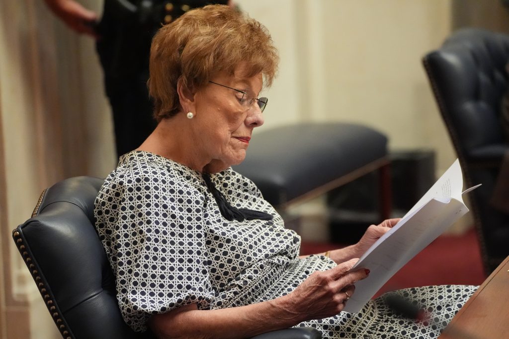 Senator English reads some papers while sitting at her desk in the Senate chamber