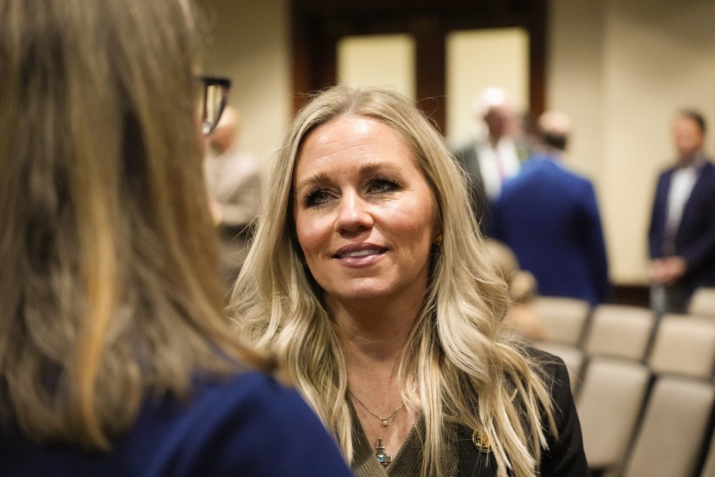 Senator Davis talks with someone in a committee room.