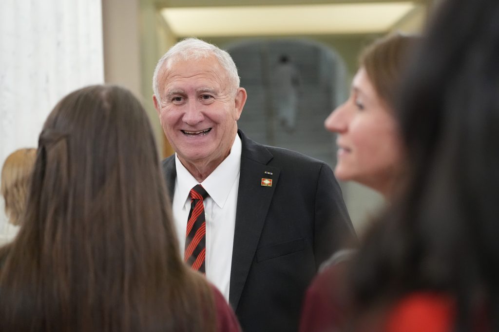 Senator Wallace smiles while talking with people in the capitol rotunda.