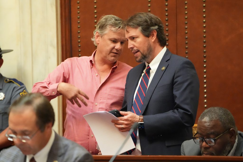 Senators Flippo and Tucker talk in the back of the Senate chamber.