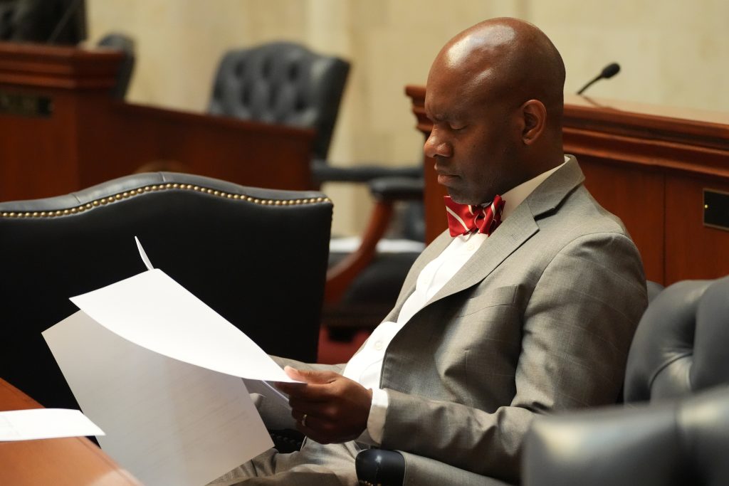 Senator Love reads some papers while sitting at his desk in the Senate chamber