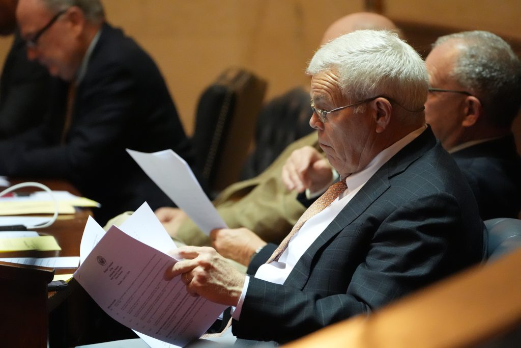 Senator Dan Sullivan reads papers at his desk in the Senate chamber
