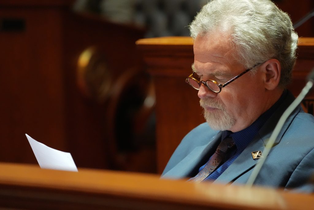 Senator Clark reads a document at his desk in the Senate chamber