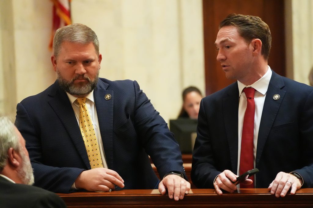 Sens Dotson and Dees talk to Sen Blake Johnson in the Senate chamber