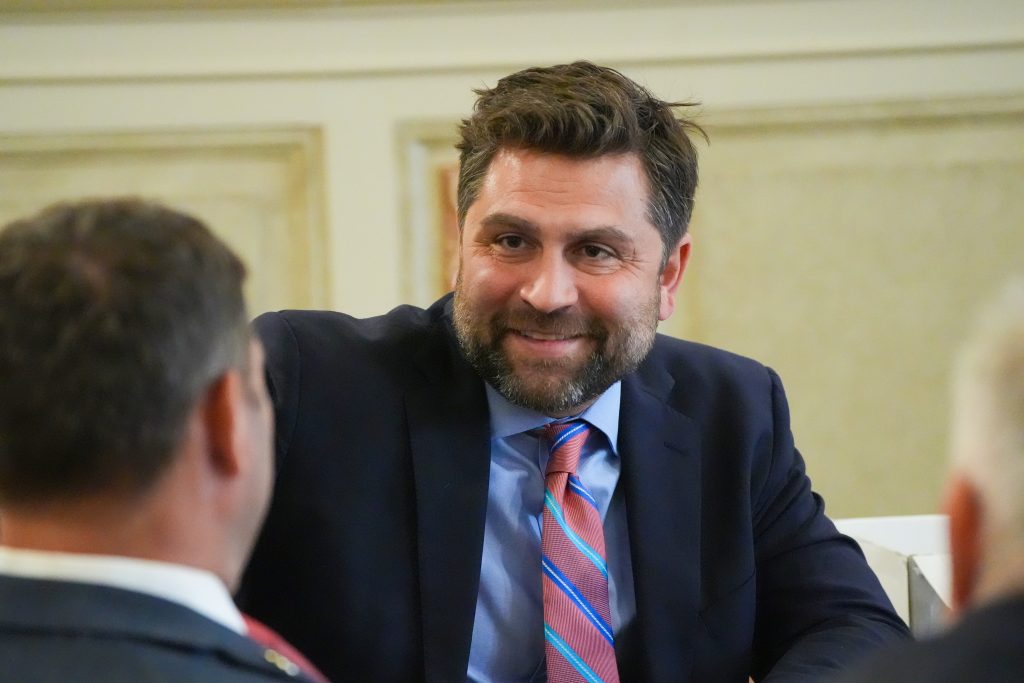 Senator Dismang smiles while talking with a colleague in the Old Supreme Court chamber