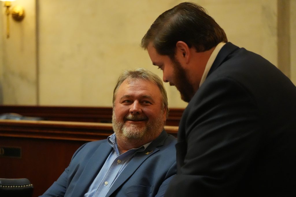 Senator Blake Johnson smiles while talking to Senator Gilmore.