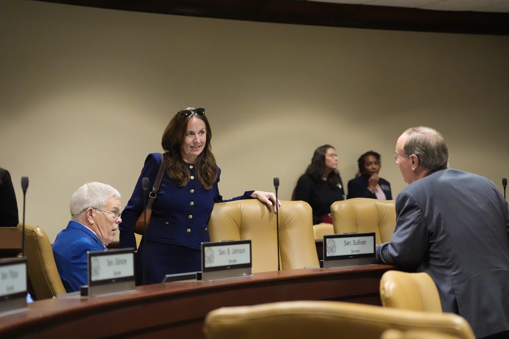 Senator Irvin talks with Senators Sullivan and Mark Johnson in a committee room