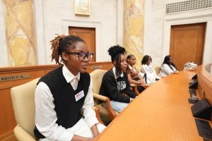 Group of girls listen to a speaker in the House of Representatives chamber