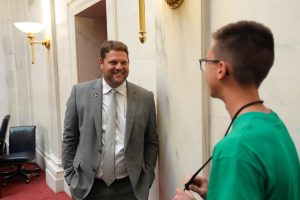 Senator Hester smiles while talking to a Boys State delegate in the Senate chamber