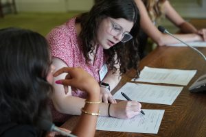 Young women take notes during a committee meeting