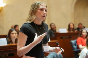 A Girls State delegate gestures while speaking in the Senate chamber