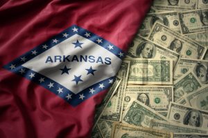 big colorful waving national flag of Arkansas state on a American money background.