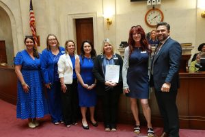 Senator Dismang poses in the Senate chamber with representatives from CASA